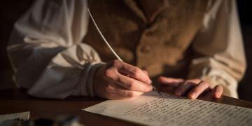 Oliver Cowdery scribing the text of the Book of Mormon. Image via Church of Jesus Christ.